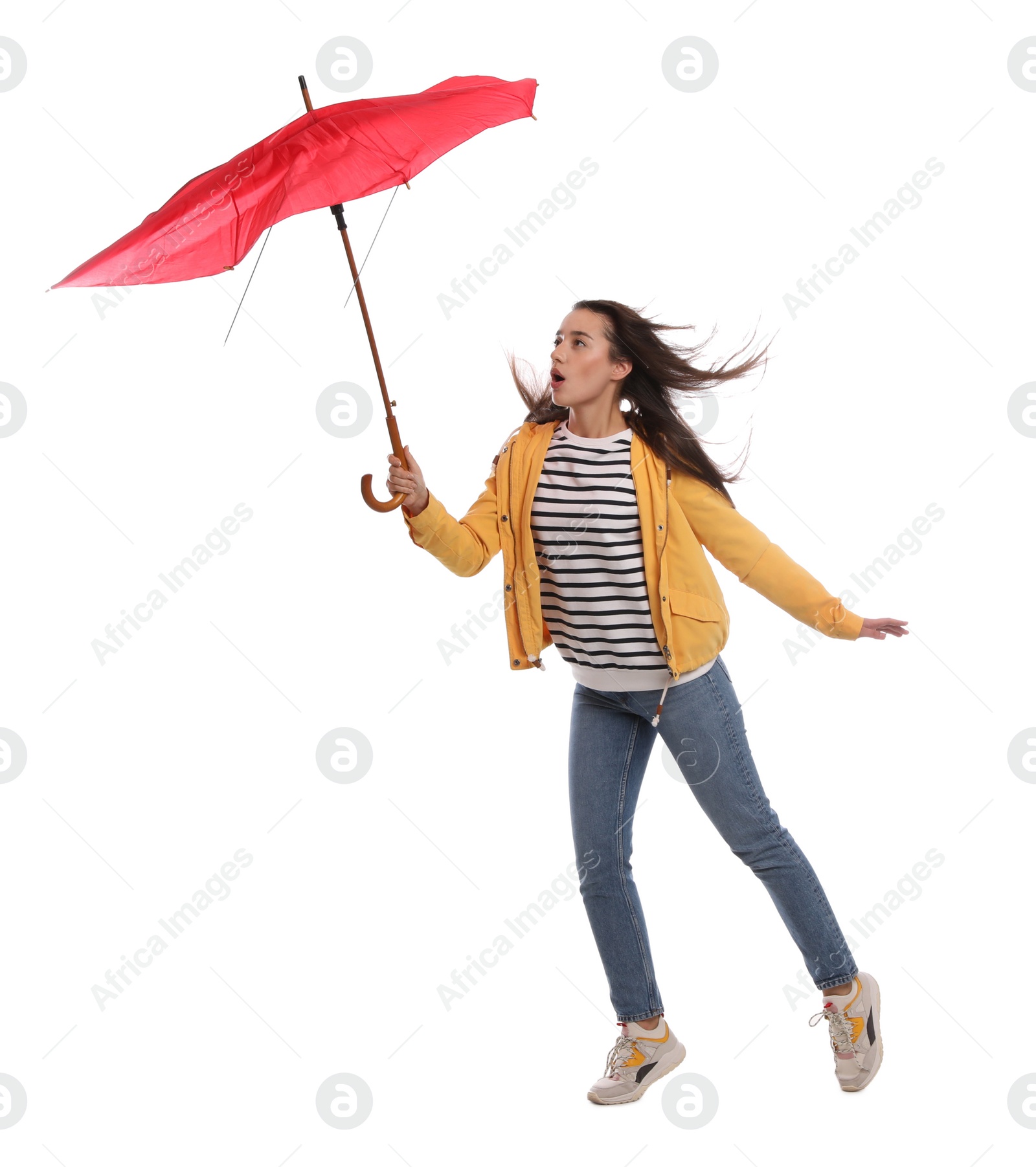 Photo of Emotional woman with umbrella caught in gust of wind on white background