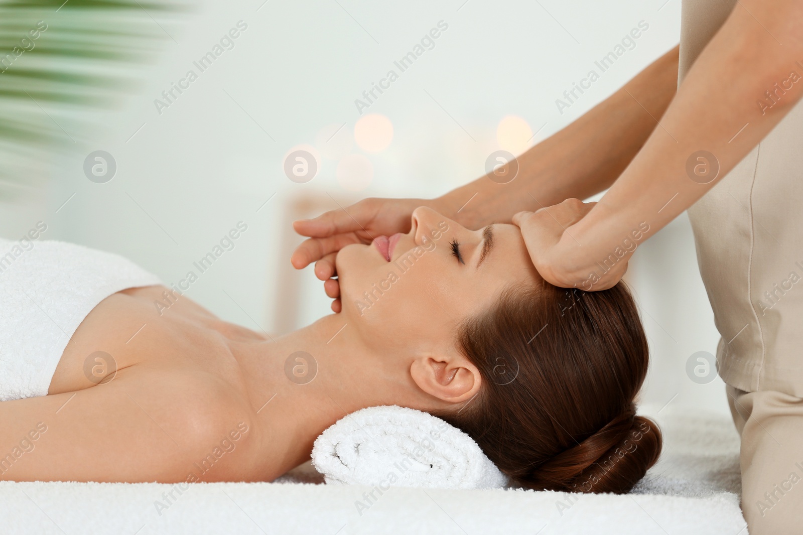 Photo of Beautiful young woman enjoying massage in spa salon