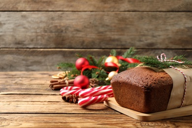 Photo of Delicious gingerbread cake, candy canes and Christmas decor on wooden table, space for text