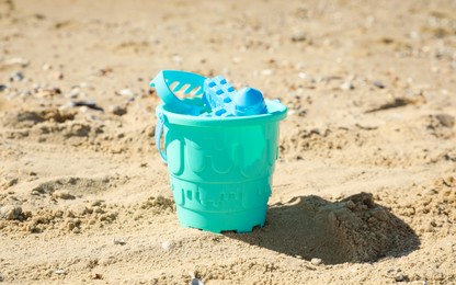 Different child plastic toys on sandy beach