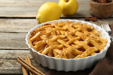 Tasty homemade quince pie with spices on wooden table. closeup