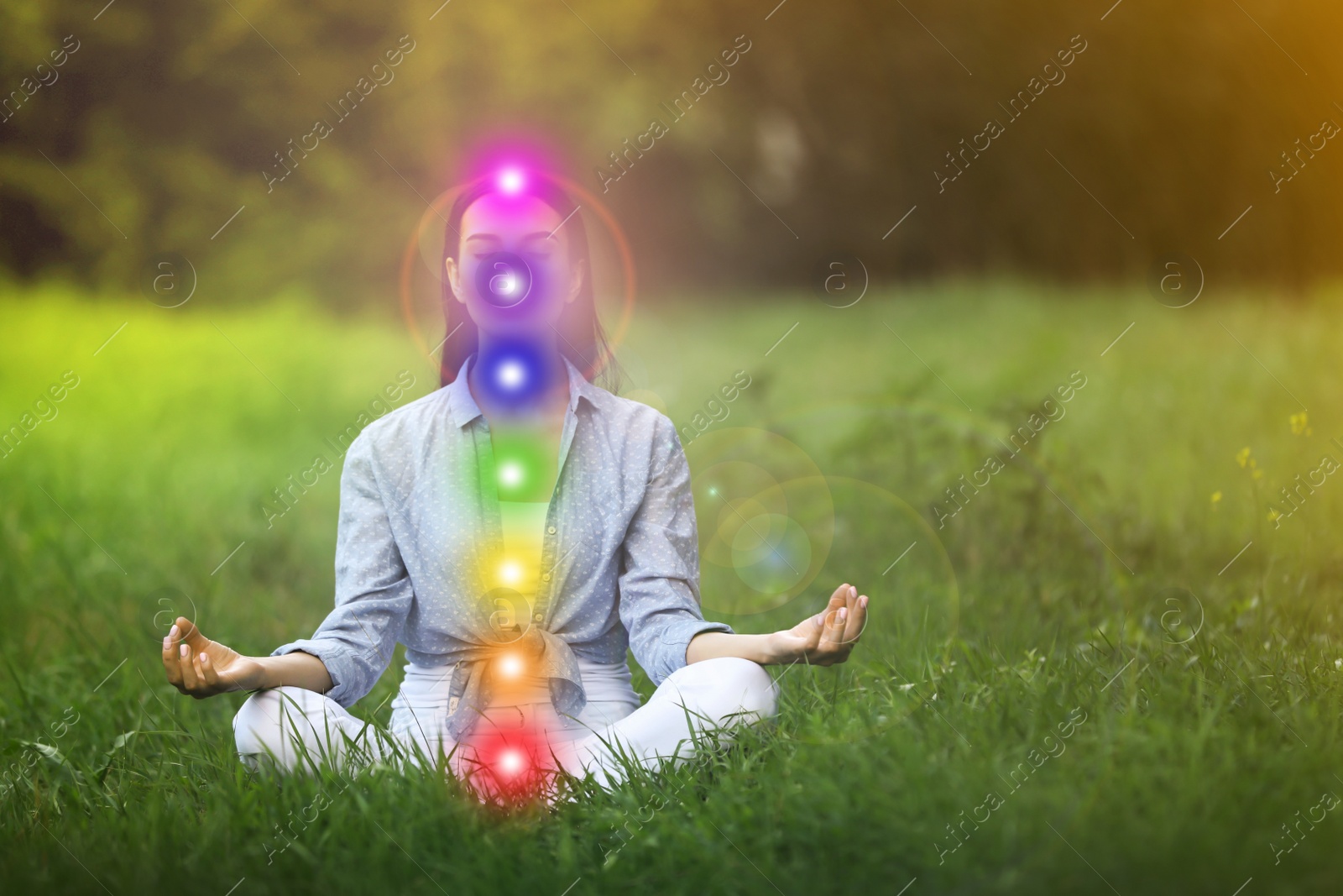 Image of Young woman meditating on green grass. Scheme of seven chakras, illustration