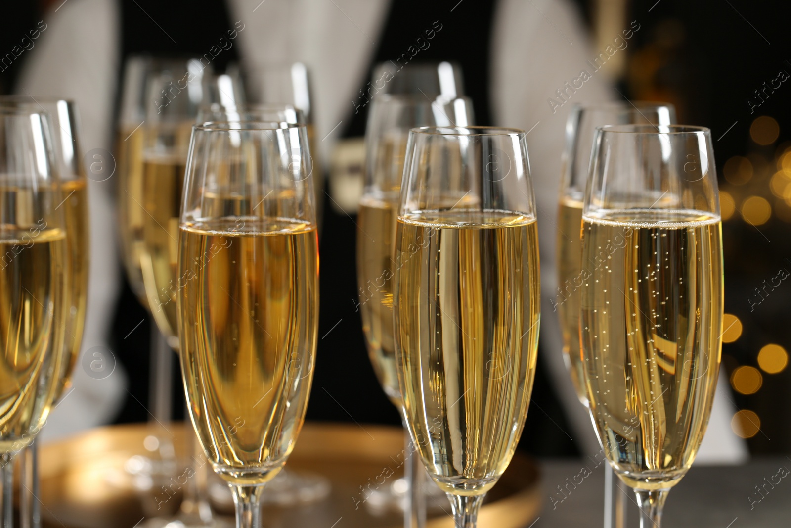Photo of Glasses of champagne and waiter in restaurant, closeup