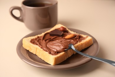 Photo of Tasty toast with chocolate paste and cup of tea served on light table