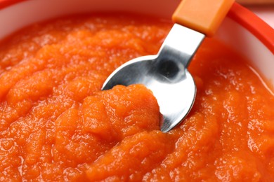 Photo of Healthy baby food. Closeup view of delicious carrot puree in bowl