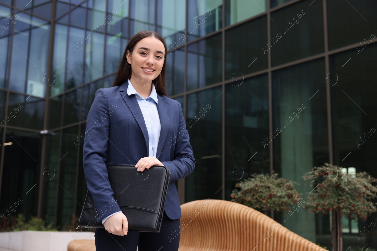 Photo of Real estate agent with leather portfolio outdoors. Space for text