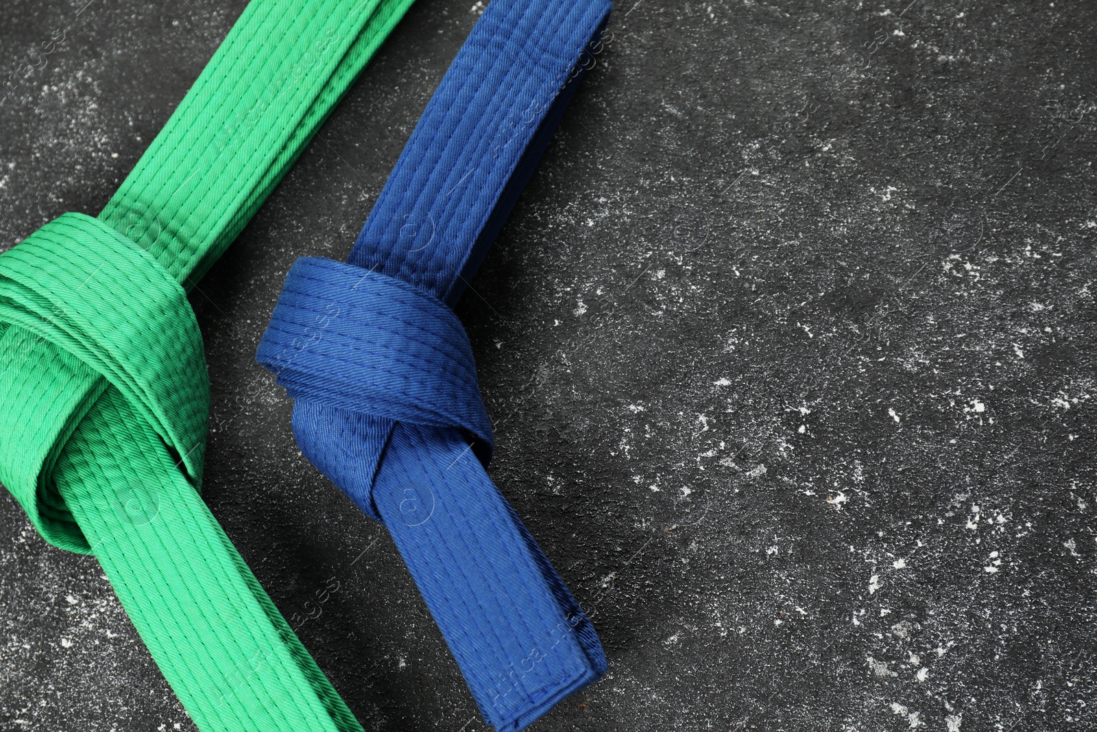 Photo of Karate belts on gray background, flat lay. Space for text