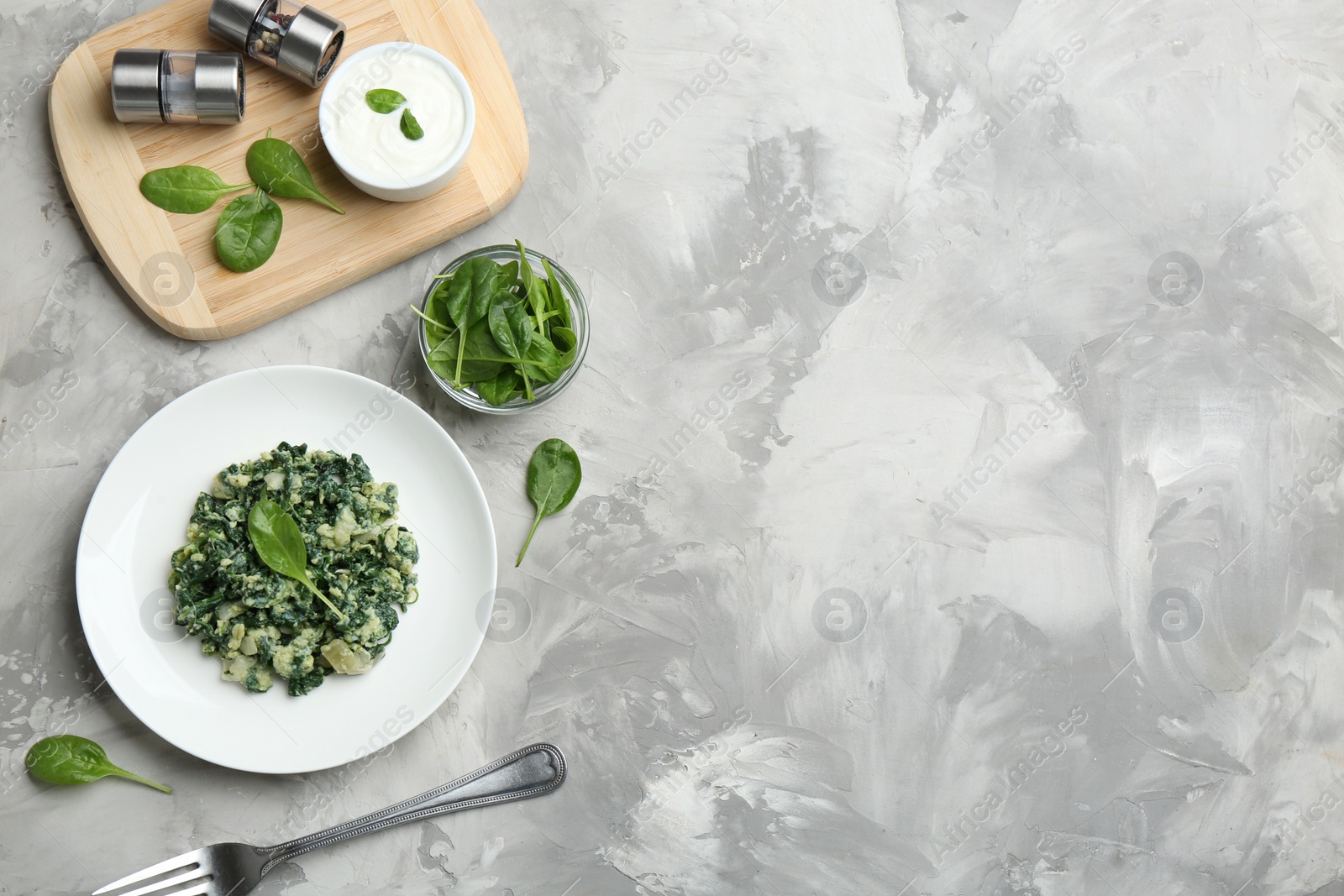 Photo of Flat lay composition with tasty spinach and space for text on grey table. Healthy food