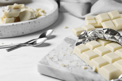 Tasty white chocolate on wooden table, closeup