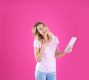 Woman using tablet for video chat on color background