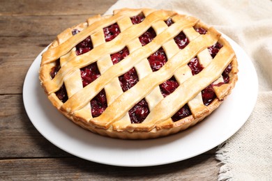 Delicious fresh cherry pie on wooden table, closeup