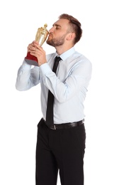 Photo of Portrait of happy young businessman kissing gold trophy cup on white background