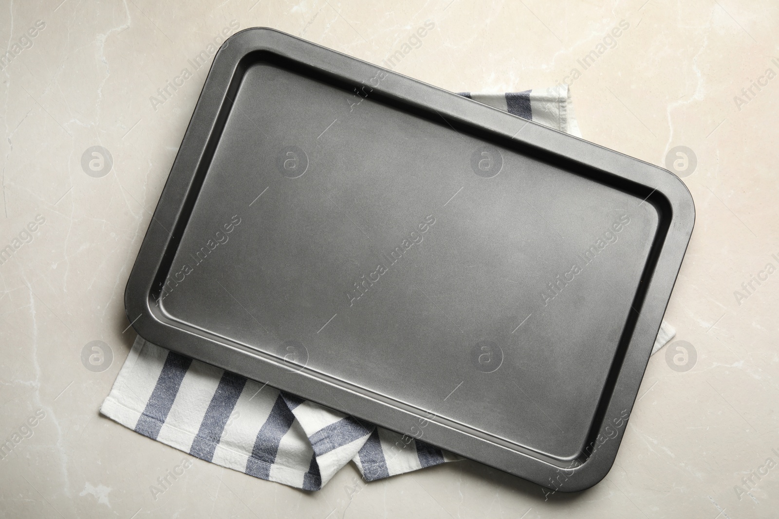 Photo of Empty oven sheet and towel on light stone background, flat lay. Space for text