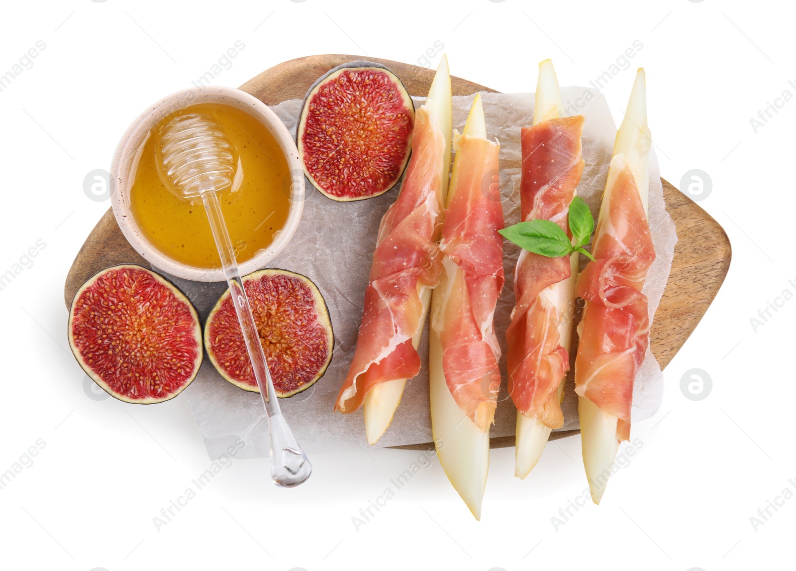 Photo of Wooden board with tasty melon, jamon, figs and honey isolated on white, top view