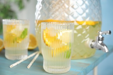 Delicious refreshing lemonade with orange slices on light blue wooden table