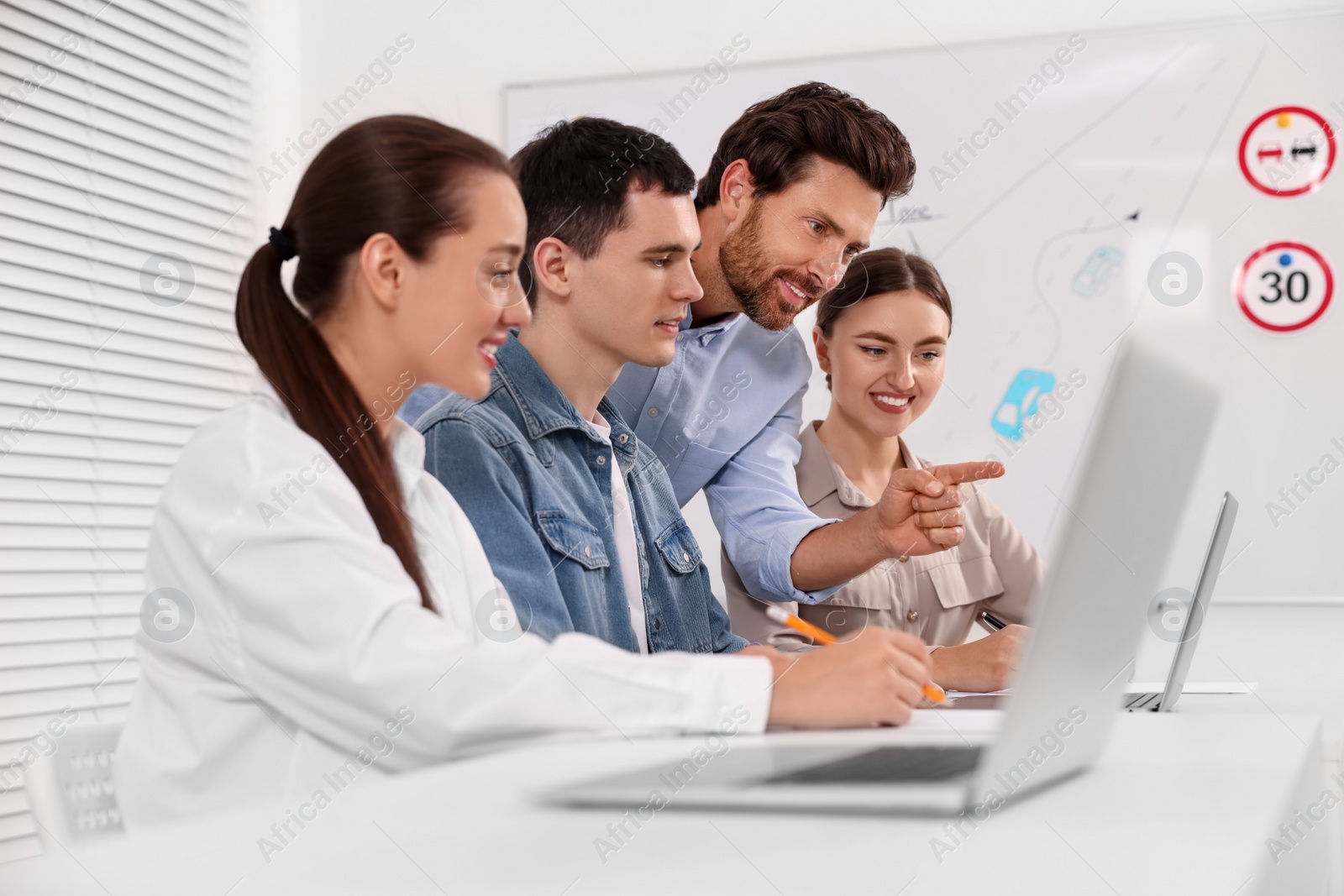 Photo of Happy teacher giving lesson in driving school