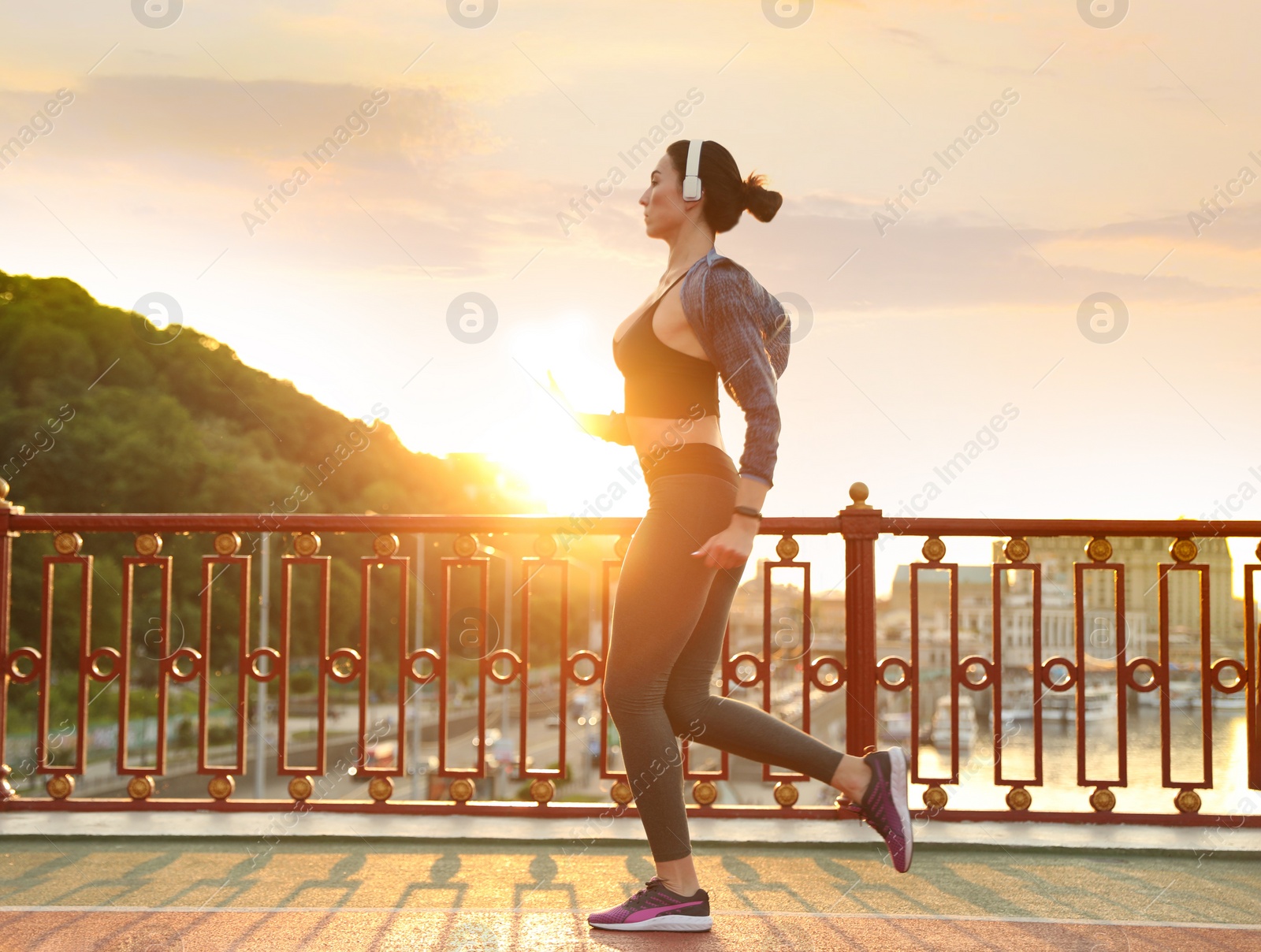 Photo of Beautiful sporty young woman running in city