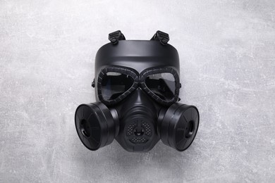 One gas mask on grey textured background, top view