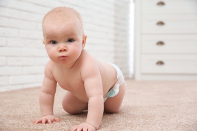 Photo of Cute little baby crawling on carpet indoors