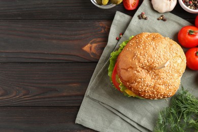 Delicious vegetarian burger and ingredients on wooden table, top view. Space for text