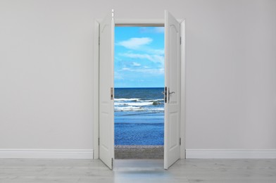 Image of Open door in white wall inviting to visit beach