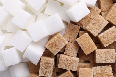 White and brown sugar cubes as background, top view