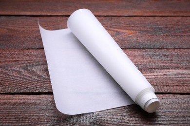 Photo of Roll of baking paper on wooden table