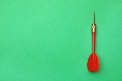 Photo of Red dart arrow on green background, top view with space for text