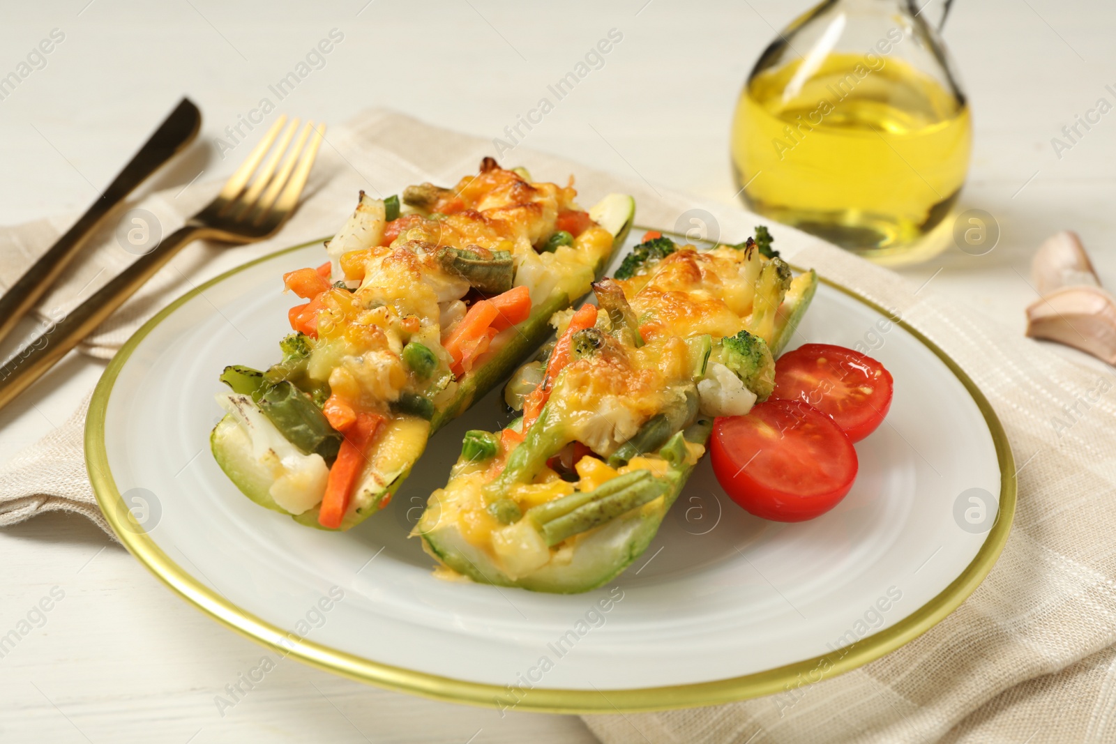 Photo of Baked stuffed zucchinis served on white wooden table, closeup