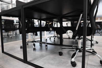 Comfortable office chairs and tables in meeting room, closeup