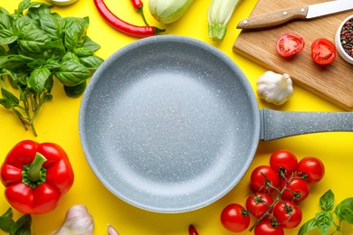 Photo of Flat lay composition with frying pan and fresh products on yellow background