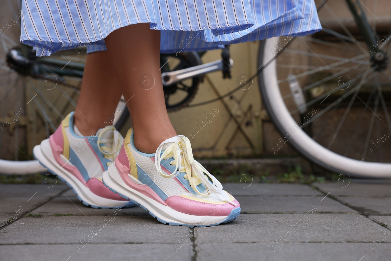 Photo of Woman wearing pair of stylish sneakers outdoors, closeup. Space for text