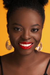 Photo of Fashionable portrait of beautiful happy woman on yellow background, closeup