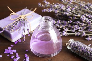 Bottle with aromatic lavender oil on wooden table