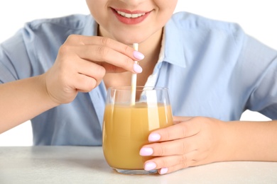 Woman with tasty pear juice at white table, closeup