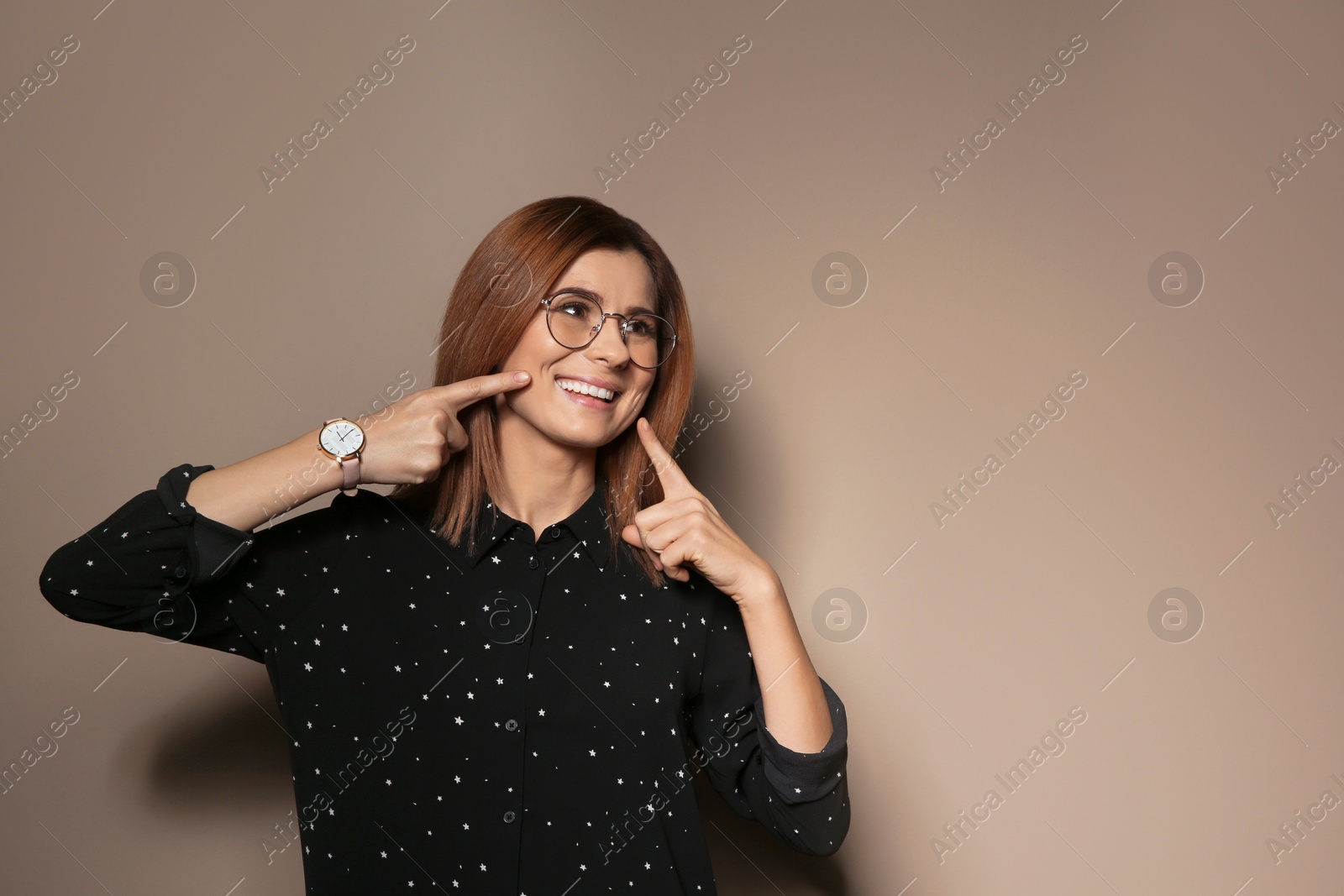 Photo of Woman showing LAUGH gesture in sign language on color background, space for text