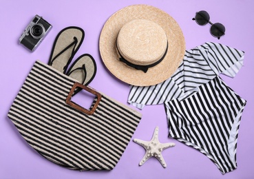 Flat lay composition with stylish beach accessories on lilac background