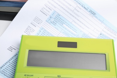 Photo of Calculator and document on table, closeup view. Tax accounting
