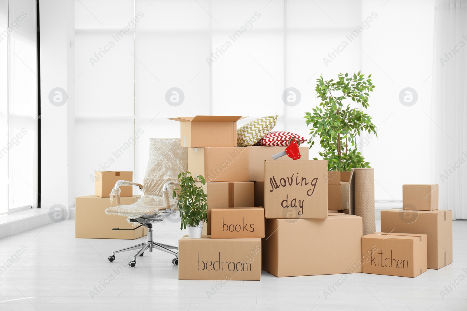 Photo of Pile of moving boxes in empty room