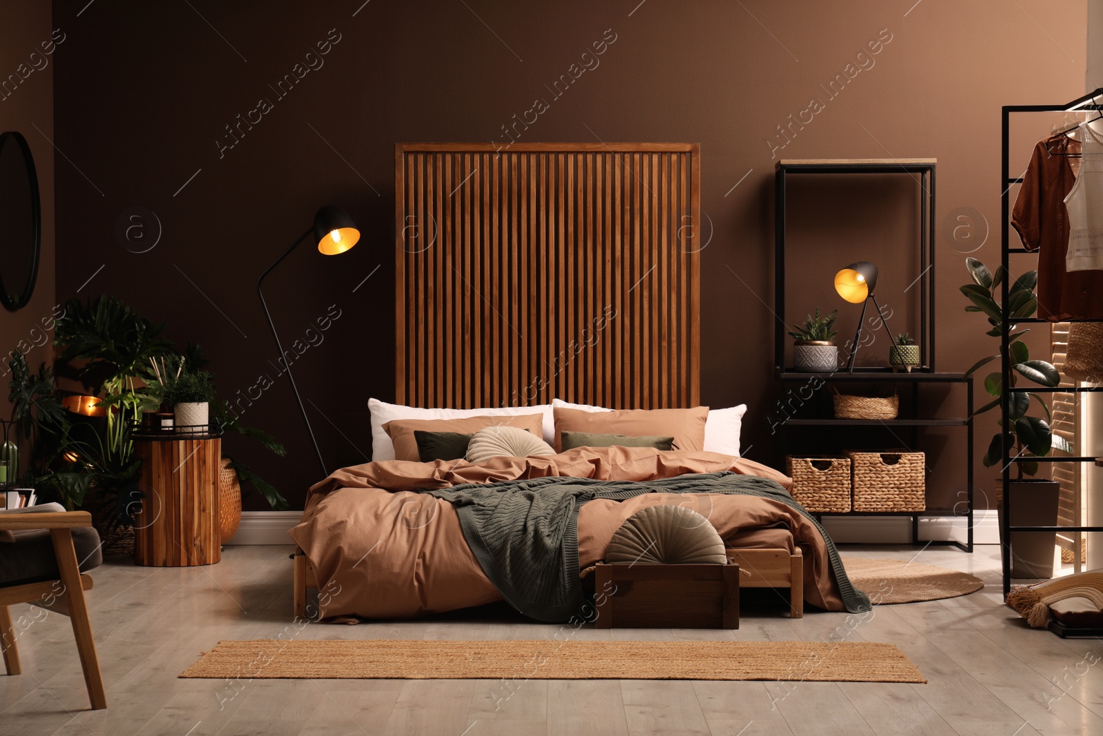 Photo of Stylish room interior with large bed near brown wall