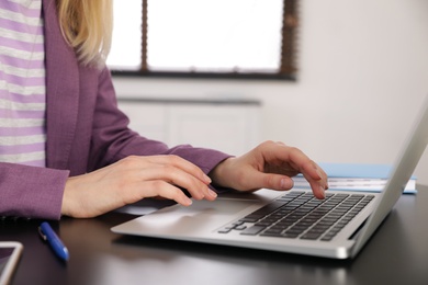 Image of Woman working on laptop at table, closeup