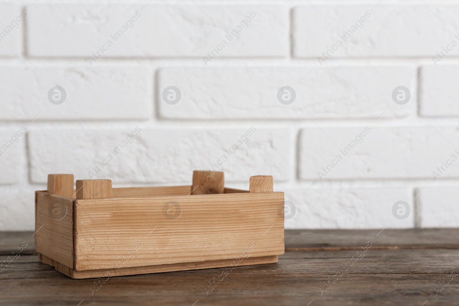 Photo of Wooden crate on table near brick wall. Space for text