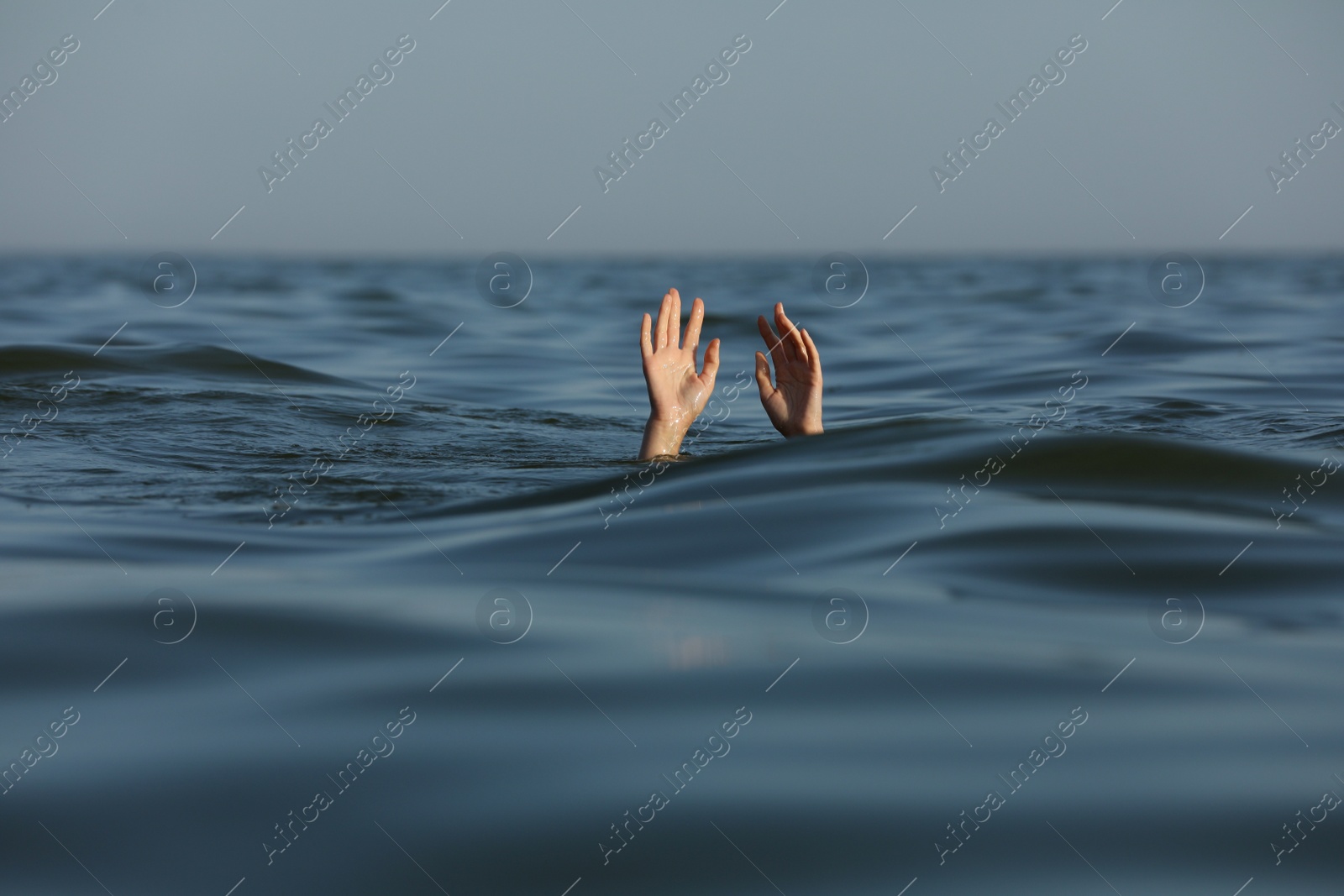 Photo of Drowning woman reaching for help in sea