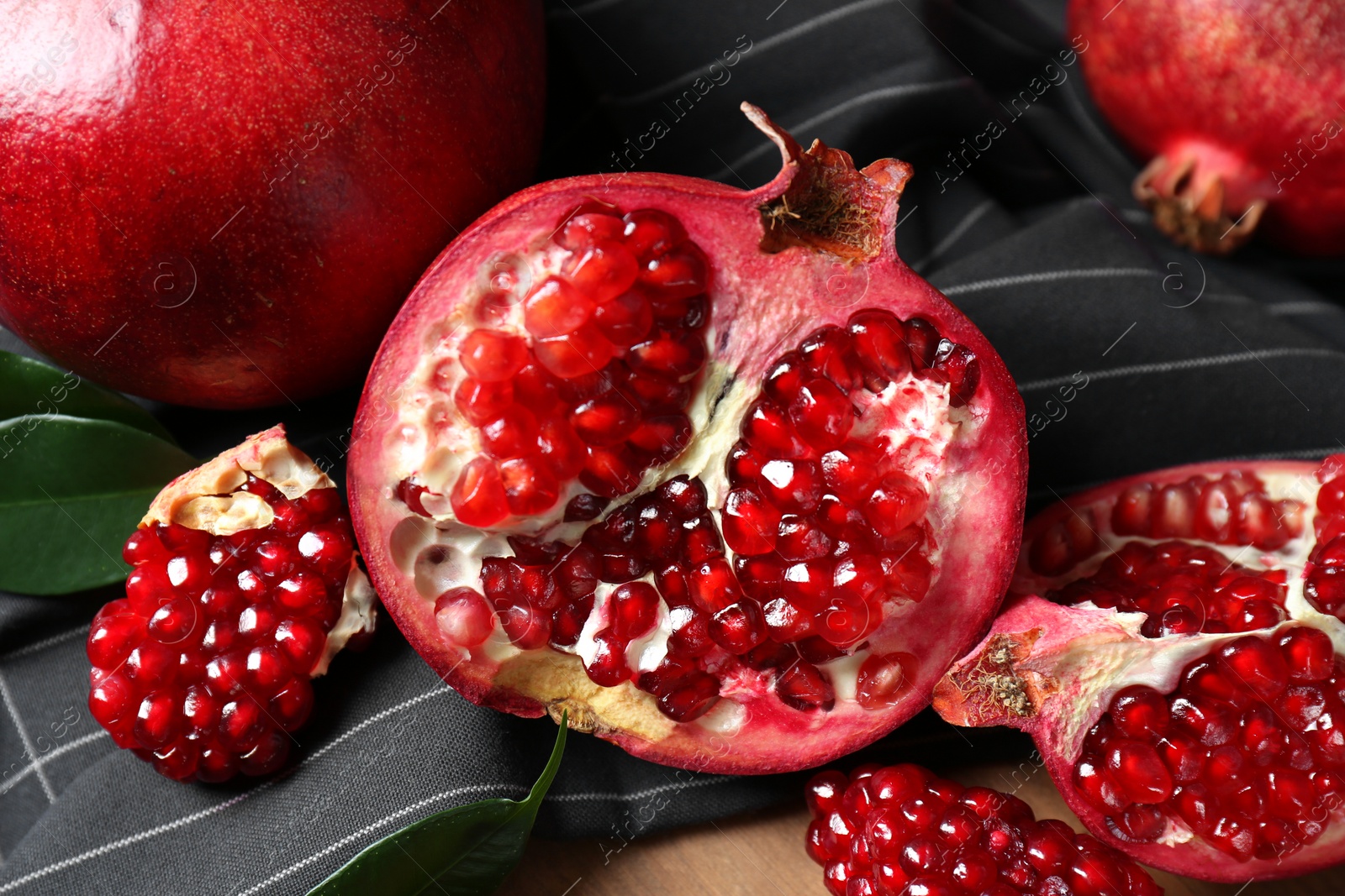 Photo of Closeup of delicious red ripe pomegranates with seeds on napkin