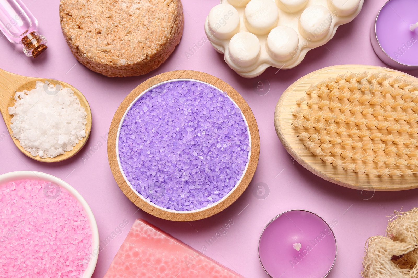 Photo of Sea salt and different spa products on pink background, flat lay