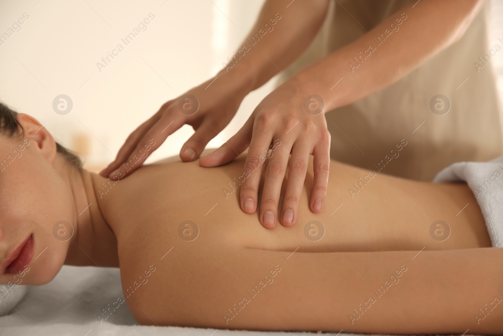 Photo of Young woman receiving back massage in spa salon, closeup