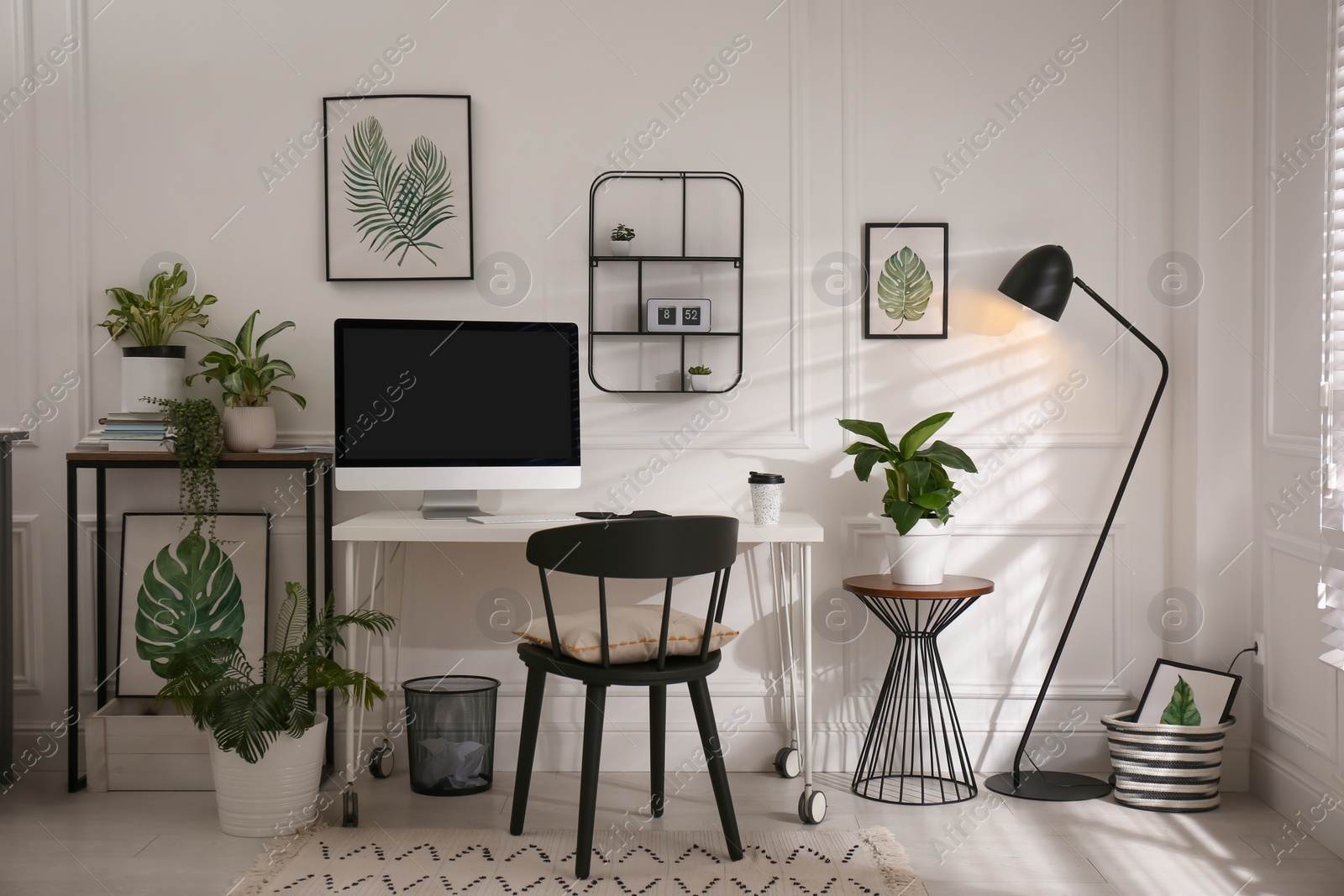 Photo of Comfortable workplace with modern computer and houseplants in room. Interior design