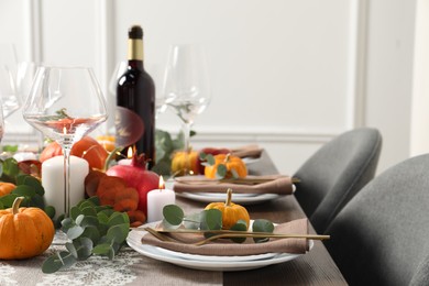 Photo of Beautiful autumn table setting. Plates, cutlery, glasses, pumpkins and floral decor