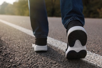 Photo of Man going along road, closeup of legs