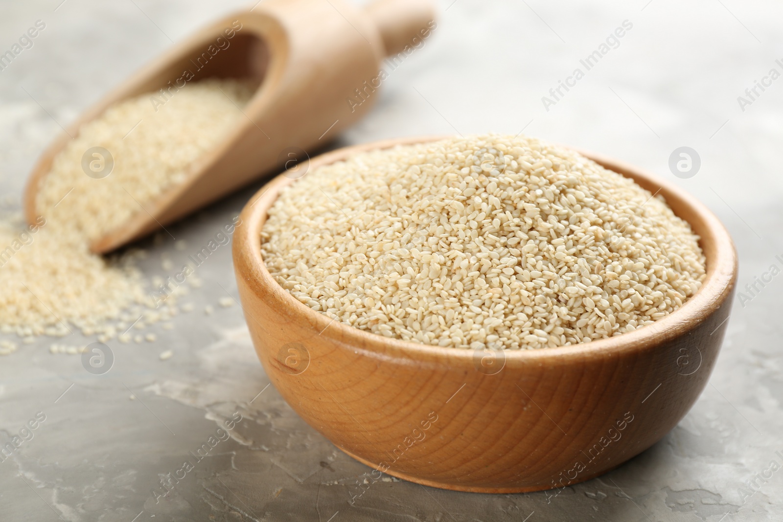 Photo of White sesame seeds on light grey table, closeup